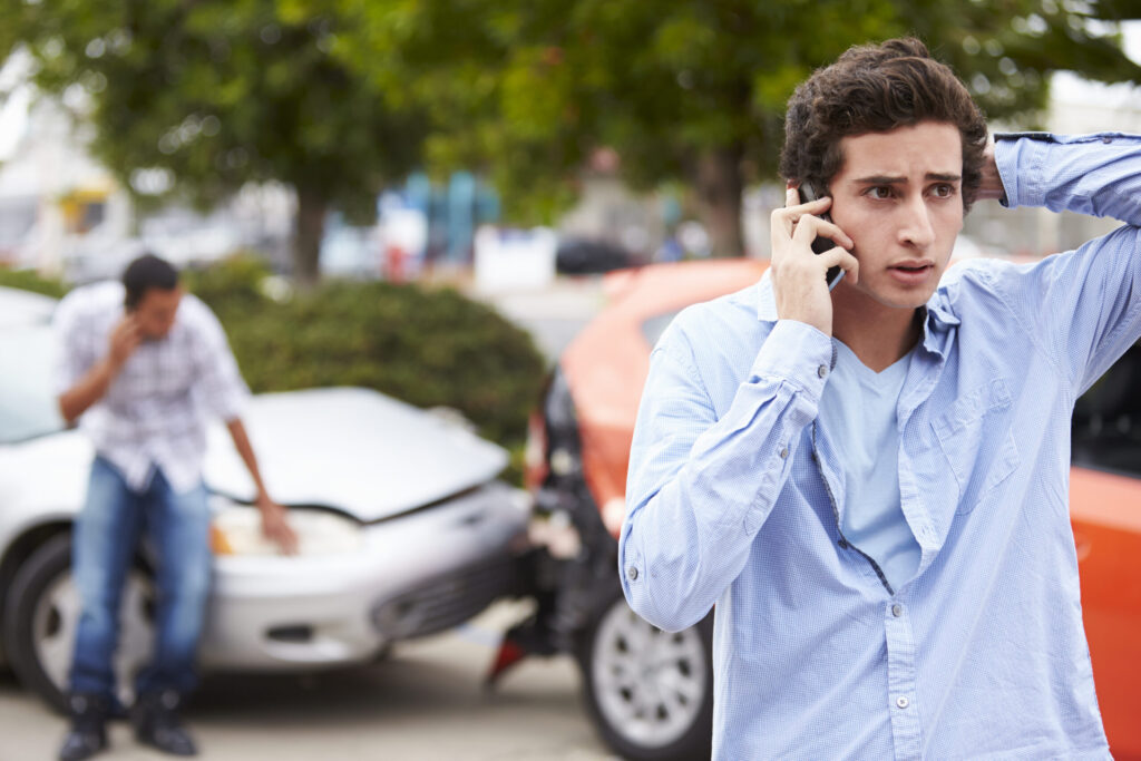 Man calling insurer after car accident