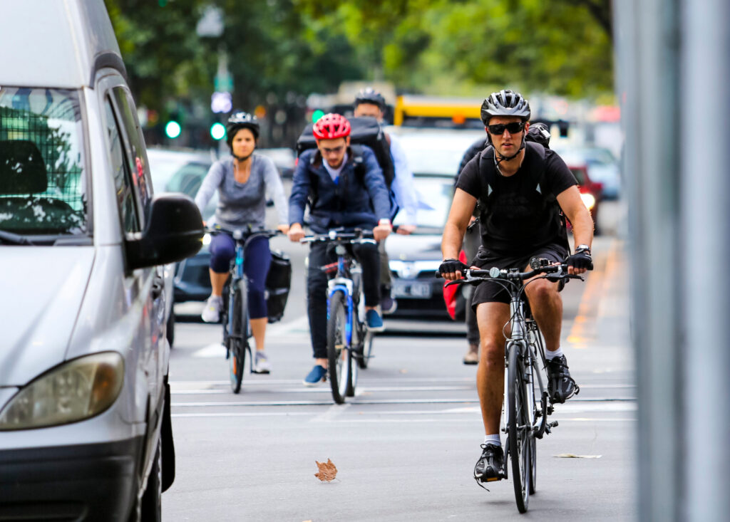 Bicycle Riders on Road Riding Alongside Cars - at Risk of Cycling Accident