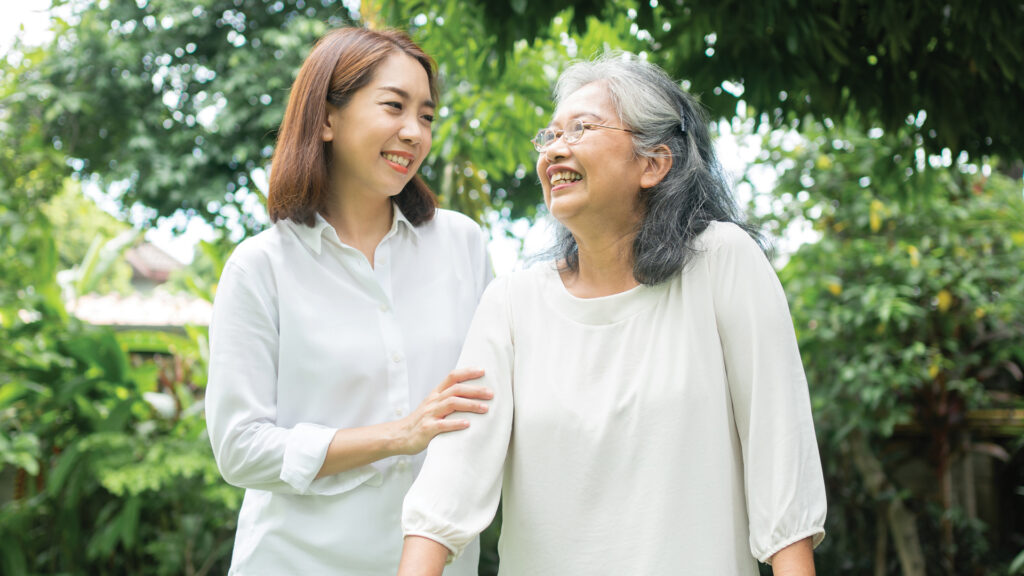 A Chinese woman and her mother smiling outdoors
