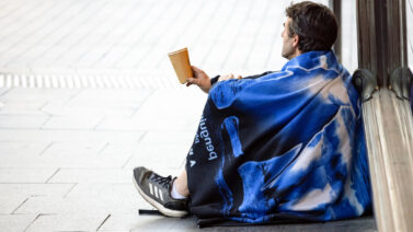 Homeless man sitting on an empty street