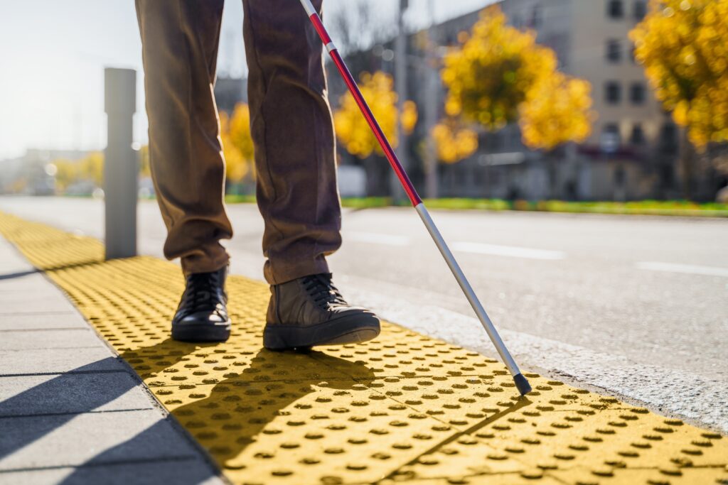 Man using a cane to walk after experiencing workplace eye injury